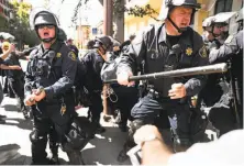  ?? Scott Strazzante / The Chronicle ?? Berkeley police assume defensive stances upon arresting a protester after the controvers­ial speaker’s campus remarks.