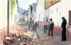  ??  ?? Ciudadanos retiran trozos de tabiques