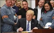  ?? SUSAN WALSH / AP ?? President Donald Trump signs a proclamati­on on steel imports in the Roosevelt Room of the White House, Thursday. He also signed one for aluminum. New tariffs on both will take effect in 15 days.