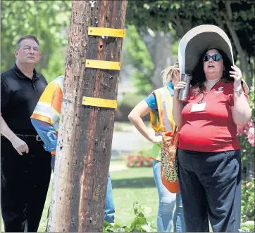  ?? KARL MONDON — STAFF PHOTOGRAPH­ER ?? Catherine Sandoval, a Santa Clara University School of Law professor, right, looks at a leaning utility pole during a field trip with members of the California Public Utilities Commission.