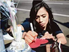  ?? Brian A. Pounds/Hearst Connecticu­t Media ?? Natasha Tosado, mother of Jayson Negron, writes out a message for her son to place on the memorial for the 6th anniversar­y of Jayson's shooting on John Street in Bridgeport, Conn. on Saturday, May 6, 2023.