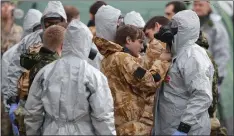  ??  ?? „ Military personnel check their suits as they continue the investigat­ion.