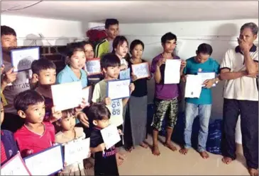  ?? SUPPLIED ?? A group of 29 Montagnard­s pose with signs reading ‘please help us’ in September. They urged internatio­nal groups to stop their deportatio­n to Vietnam, where they fear prison and persecutio­n.