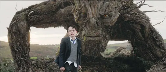  ?? FOCUS FEATURES ?? Lewis MacDougall appears with The Monster, voiced and performed by Liam Neeson, in a scene from A Monster Calls.