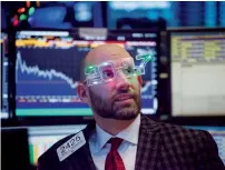  ?? — Bloomberg ?? A trader works on the floor of the New York Stock Exchange. US markets have been transition­ing to electronic trading.