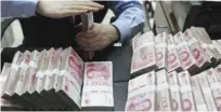  ?? - Reuters file photo ?? SLUGGISH: An employee counts Chinese yuan banknotes at a bank in Hefei, Anhui province. Chinese economy has weakened significan­tly in the past few months.