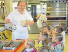  ?? FOTOS: KINDERHAUS ?? Jungen und Mädchen aus Heroldstat­t zu Gast bei Bäcker Peter Mangold in Laichingen. Die jungen Gäste durften Gebäck ausstechen.