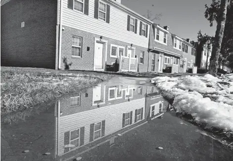  ?? KENNETH K. LAM/BALTIMORE SUN ?? Apartment units on Edisto Way, part of the Commons at White Marsh complex, reflected in water from recently melted snow. The complex is one of about 90 that participat­ed in a Baltimore County program to pay off overdue rent at a discount.