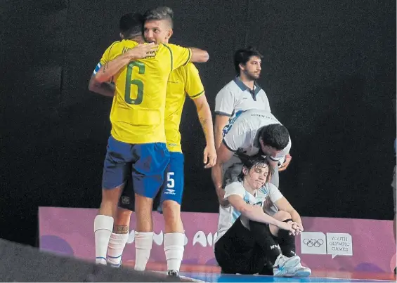  ?? G. ADRASTI ?? Euforia por un lado, decepción por el otro. Se abrazan Neguinho (el 6) y Caio (el 5), de Brasil. Se resigna en el piso el argentino Raggiati.