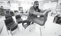  ?? CHARLIE NEIBERGALL AP ?? Custodian Tracy Harris cleans chairs in a classroom in Des Moines, Iowa. A new study shows young children are least likely to spread the coronaviru­s.