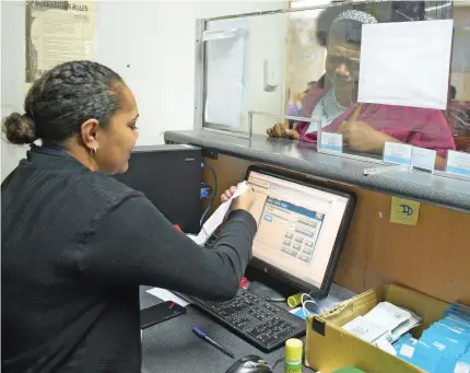  ?? Photo: Ronald Kumar ?? An Immigratio­n office staff (left) attends to a customer with her passport in Suva on September 13, 2019.