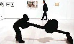  ??  ?? A man walks past an exhibit by George Lappas entitled 'Gardener with a small bear' at the National Museum of Contempora­ry Art in Athens.