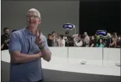  ?? ?? Apple CEO Tim Cook poses for photos in front of the company’s new Apple Vision Pro headsets in a showroom on the Apple campus in Cupertino on Monday.