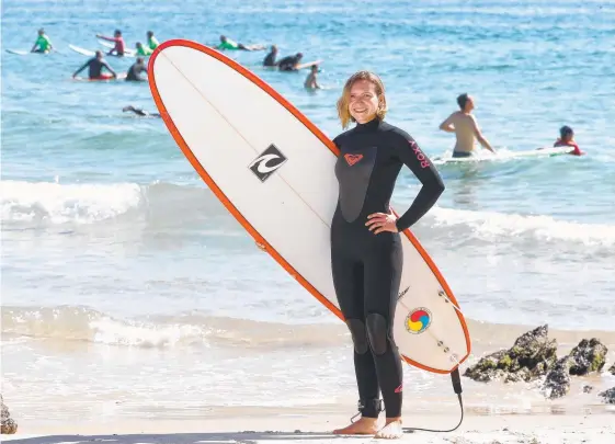  ?? Picture: RICHARD GOSLING ?? At least is sunny ... Dasha Solomkina at Currumbin yesterday was one of thousands ready to see the surf improve on the Coast.