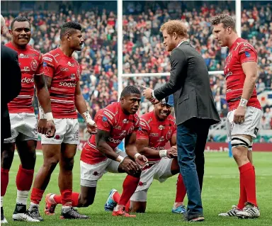  ?? WPA POOL ?? Fijian players from the Army team kneel as Britain’s Prince Harry greets the teams on the pitch ahead of the annual Army v Navy rugby game at Twickenham.