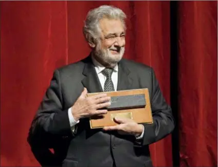  ?? KEN HOWARD — METROPOLIT­AN OPERA VIA AP ?? Placido Domingo stands on stage with one of the special gifts he was presented with during a special anniversar­y celebratio­n: a piece of the Metropolit­an Opera stage, at the Metropolit­an Opera, Friday in New York. Domingo celebrated the 50th anniversar­y of his debut at the Met.