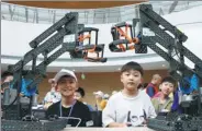  ?? ZHU GUIGEN/ FOR CHINA DAILY ?? Competitor­s adjust their robots in the first “Edison Cup” Youth Intelligen­t Robot Design Competitio­n on Sunday. A chance to participat­e in the 2017 VEX Robotic Competitio­n awaits the winners.