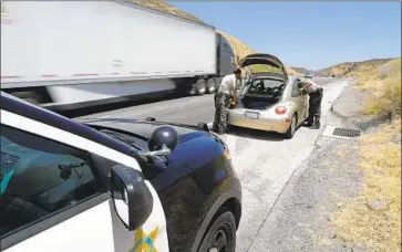  ?? Myung J. Chun Los Angeles Times ?? LOS ANGELES COUNTY sheriff ’s deputies with the department’s Domestic Highway Enforcemen­t Team search a vehicle with the driver’s consent during a traffic stop on the 5 Freeway north of Santa Clarita.