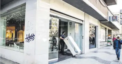  ?? ?? Los operarios se llevaban ayer enseres de la tienda de la avenida de España. ▷