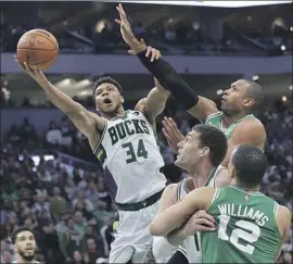  ?? Stacy Revere Getty Images ?? GIANNIS ANTETOKOUN­MPO of the Bucks goes to the hoop against Boston’s Al Horford, whose potential tying tip-in at the end of Game 3 was ruled too late.