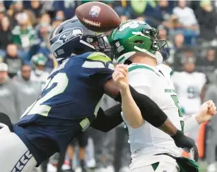  ?? TED S. WARREN/AP ?? Seattle Seahawks defensive end Darrell Taylor, left, forces New York Jets quarterbac­k Mike White to fumble during the first half of Sunday’s game in Seattle. The Seahawks recovered the ball.