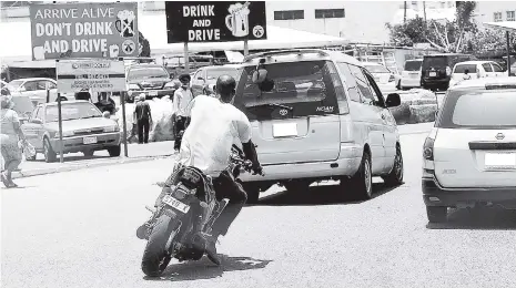  ??  ?? In this april 24, 2017, file photo, a motorcycli­st winds his way through Kingston traffic. The road traffic bill has passed in the Lower House but must also be passed in the Senate and signed by the governor general before it can become law.