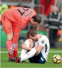  ?? CATHERINE IVILL ?? Harry Kane reacts in pain after twisting an ankle in a collision with Bournemout­h goalkeeper Asmir Begovic.