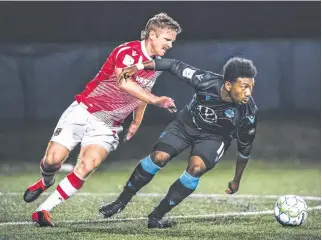  ?? CANADIAN PREMIER LEAGUE ?? HFX Wanderers striker Akeem Garcia, right, breaks away from a Cavalry FC defender during a 2020 Canadian Premier League match at the Island Games in Charlottet­own.