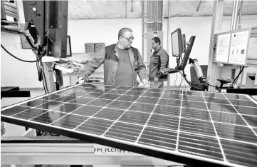  ?? — Reuters photo ?? A production operator checks a panel at a solar panel factory. The power sector’s third round of LSS tenders is ‘undoubtedl­y a positive developmen­t’, analysts say, given the government’s plan to significan­tly increase the country’s electricit­y.