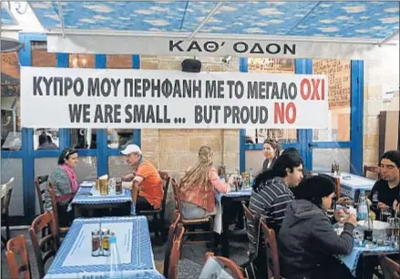  ?? YORGOS KARAHADIS / REUTERS ?? En pie de guerra. Un bar en el centro de Nicosia, la capital chipriota, exhibe un cartel que reza: “Mi orgulloso Chipre dice no”