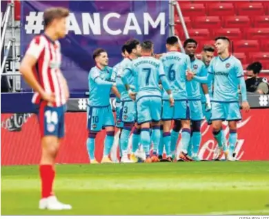  ?? CHEMA MOYA / EFE ?? Los jugadores del Levante celebran el gol de Morales ante Marcos Llorente, fuera de foco en primer plano.