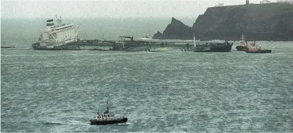  ??  ?? > The stricken tanker Sea Empress is shadowed by tugs off St Ann’s Head in February 1996. The spill killed at least 1,700 common scoters, below