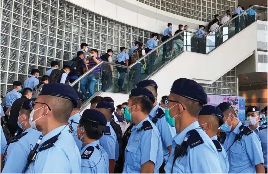  ??  ?? Mob handed: Some 200 police officers marched into the offices of Hong Kong pro-democracy newspaper Apple Daily