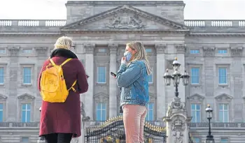  ??  ?? Masked-up visitors outside Buckingham Palace in London, where new rules are due.