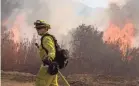  ?? JOHN CETRINO/EPA-EFE ?? A Cal Fire firefighte­r works on the Maria Fire spreading in the hills near Ventura, Calif., northwest of Los Angeles, on Friday.