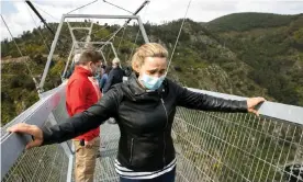  ?? Photograph: Violeta Santos Moura/Reuters ?? A visitor grips both sides of the bridge as she attempts to walk its 516 metre-span.