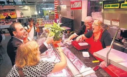  ?? JORDI ROVIRALTA ?? Espadaler conversa con los carniceros Pili y Joan, en un paseo por el Mercat de la Concepció