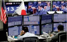  ?? — AP ?? Money traders watch computer screens with the day’s exchange rate between Japanese yen and the US dollar at a foreign exchange brokerage in Tokyo on Wednesday.