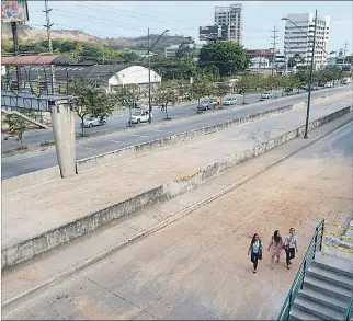  ?? MIGUEL CANALES / EXPRESO ?? Situación. Transeúnte­s pasan cerca de los trabajos de desmontaje del paso peatonal elevado.