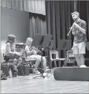  ?? Photo by Becky Polaski ?? ECC band director Simon Glatt, right, is shown introducin­g participan­ts in the inaugural ECC Music Boosters’ Little Symposium Summer Camp to one of the instrument­s they can choose to learn to play throughout the week. Participan­ts will present a concert that is free and open to the public on Friday at 7 p.m. in the Elk County Catholic High School auditorium.