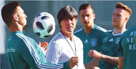  ?? AFP ?? Germany’s coach Joachim Loew speaks with his players as he leads a training session in Vatutinki, near Moscow, on Friday. Nine of the players selected by Loew for the World Cup in Russia were part of the title-winning squad four years ago.