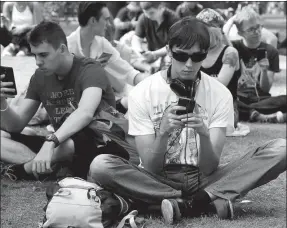  ?? PROVIDED TO CHINA DAILY ?? People use their mobile devices at a park in Moscow.