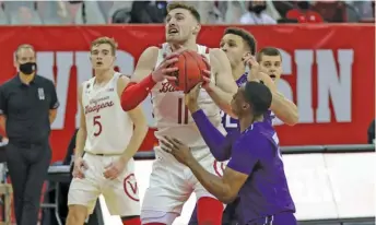  ?? GETTY IMAGES ?? Northweste­rn’s Chase Audige (right) strips the ball from Wisconsin’s Micah Potter on Wednesday.