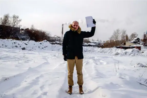  ?? (Courtesy of Denis Karagodin) ?? Denis Karagodin holds the act of execution at the site in Tomsk where he believes his great-grandfathe­r’s body was dumped