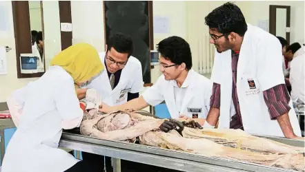  ??  ?? Melaka-Manipal students looking at a dissected human cadaver.