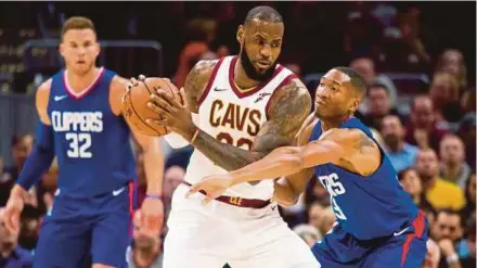  ?? AFP PIC ?? Cavaliers’ LeBron James, with the ball, tries to go past Clippers’ Wesley Johnson during their game in Cleveland on Friday.