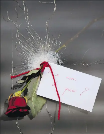  ?? — GETTY IMAGES ?? A rose is placed through a bullet hole at a restaurant on Rue de Charonne following Friday’s terrorist attacks in Paris. France will observe three days of national mourning.