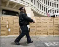  ?? MATT ROURKE - THE ASSOCIATED PRESS ?? Police Capt. Sekou Kinebrew helps load boxes of police donated Thanksgivi­ng meals in Philadelph­ia on Tuesday.