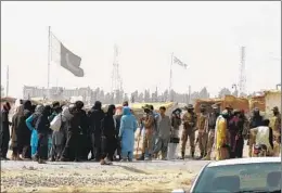  ?? BANARAS KHAN AFP VIA GETTY IMAGES ?? Stranded people speak with Pakistani troops in Chaman on Wednesday after the Taliban claimed they had captured the Afghan side of the border crossing.