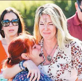  ??  ?? Momentos de horror. Dos mujeres esperan noticias de sus familiares en los alrededore­s de la escuela Marjory Stoneman Douglas, ayer por la tarde.